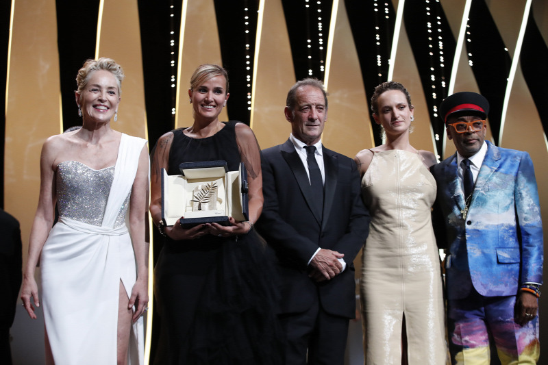 Cannes, 2021. július 17. Julia Ducournau francia rendező (b2), miután átvette a fesztivál fődíját, az Arany Pálmát a 74. Cannes-i Nemzetközi Filmfesztivál záróünnepségén 2021. július 17-én. Balról Sharon Stone amerikai, Vincent Lindon (k), Agathe Rousselle francia színész (j2), valamint Spike Lee amerikai rendező, színész, producer, a zsűri elnöke. Ducournau a Titán című alkotásával érdemelte ki az elismerést. MTI/EPA/Sebastien NogierFORRÁS: MTI/EPA/SEBASTIEN NOGIER